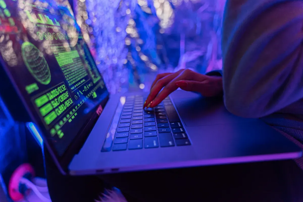 Infrastruktur am Edge - Eine Person tippt auf einem Laptop mit einer dunkel gestalteten Oberfläche und befasst sich mit IT-He