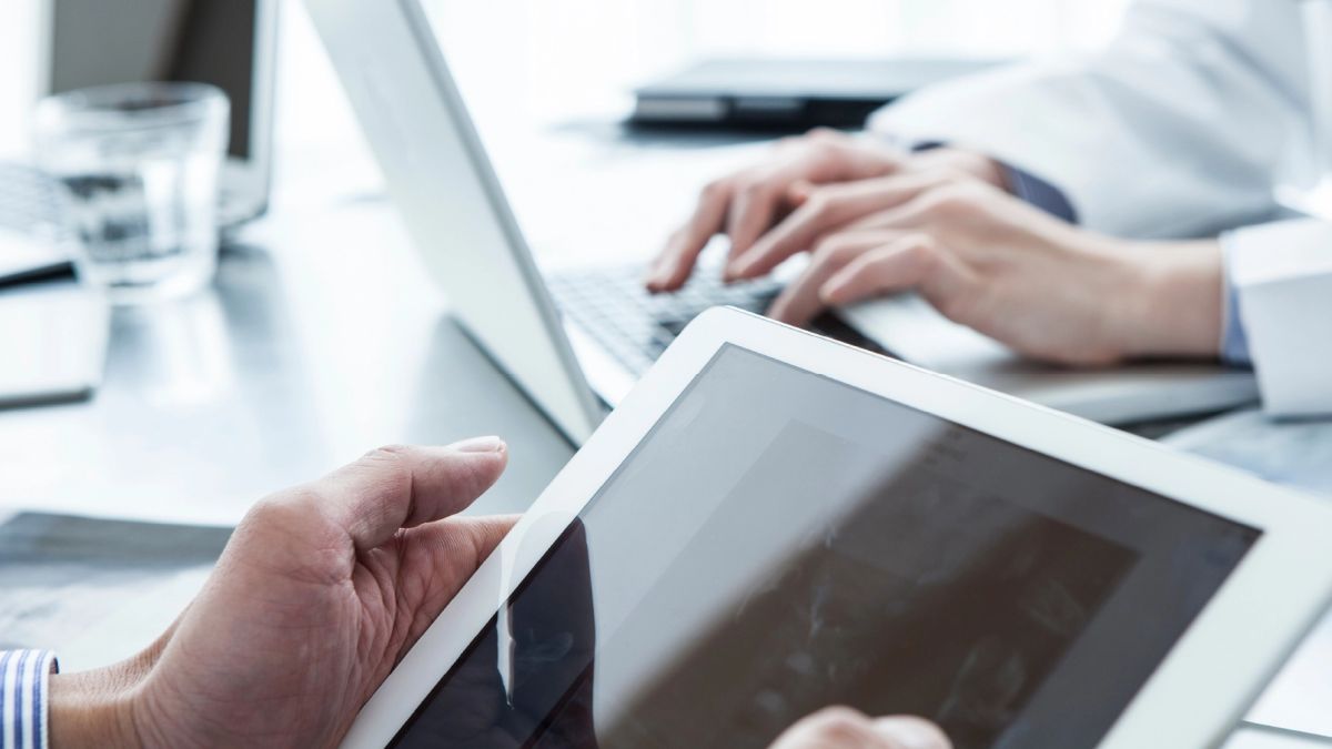 Eine Gruppe von Ärzten in einem Krankenhaus nutzt einen Tablet-Computer zur Digitalisierung.