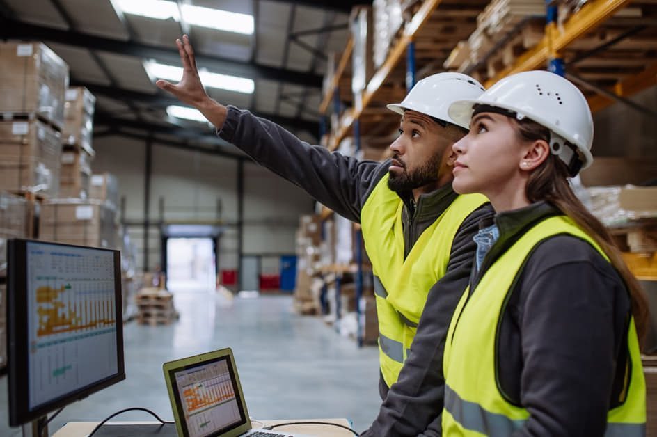 Arbeiter in einem Lager analysieren Erfolgsfaktoren am Computerbildschirm
